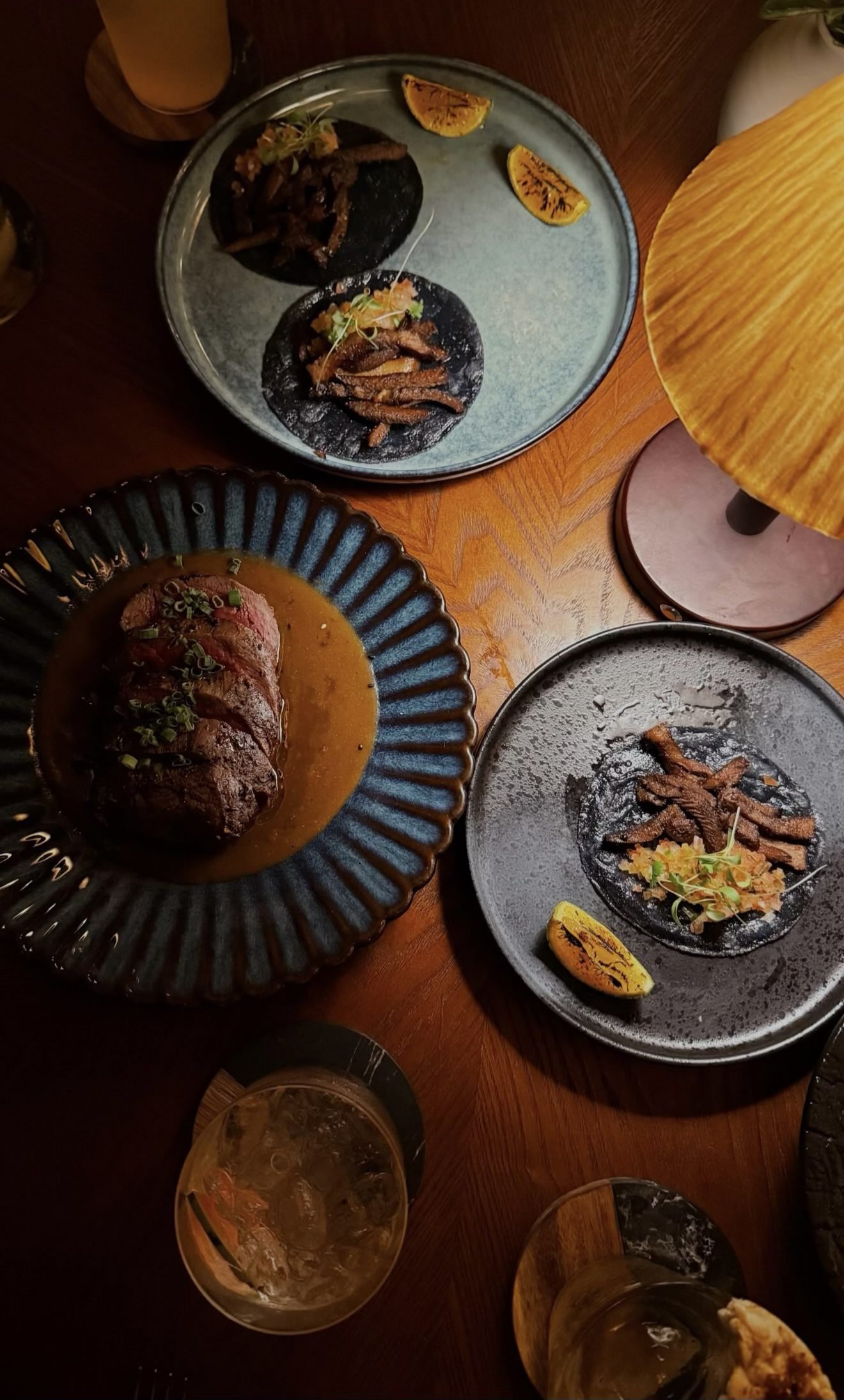 Platos de la robata de Flamante vistos desde arriba sobre la mesa de madera