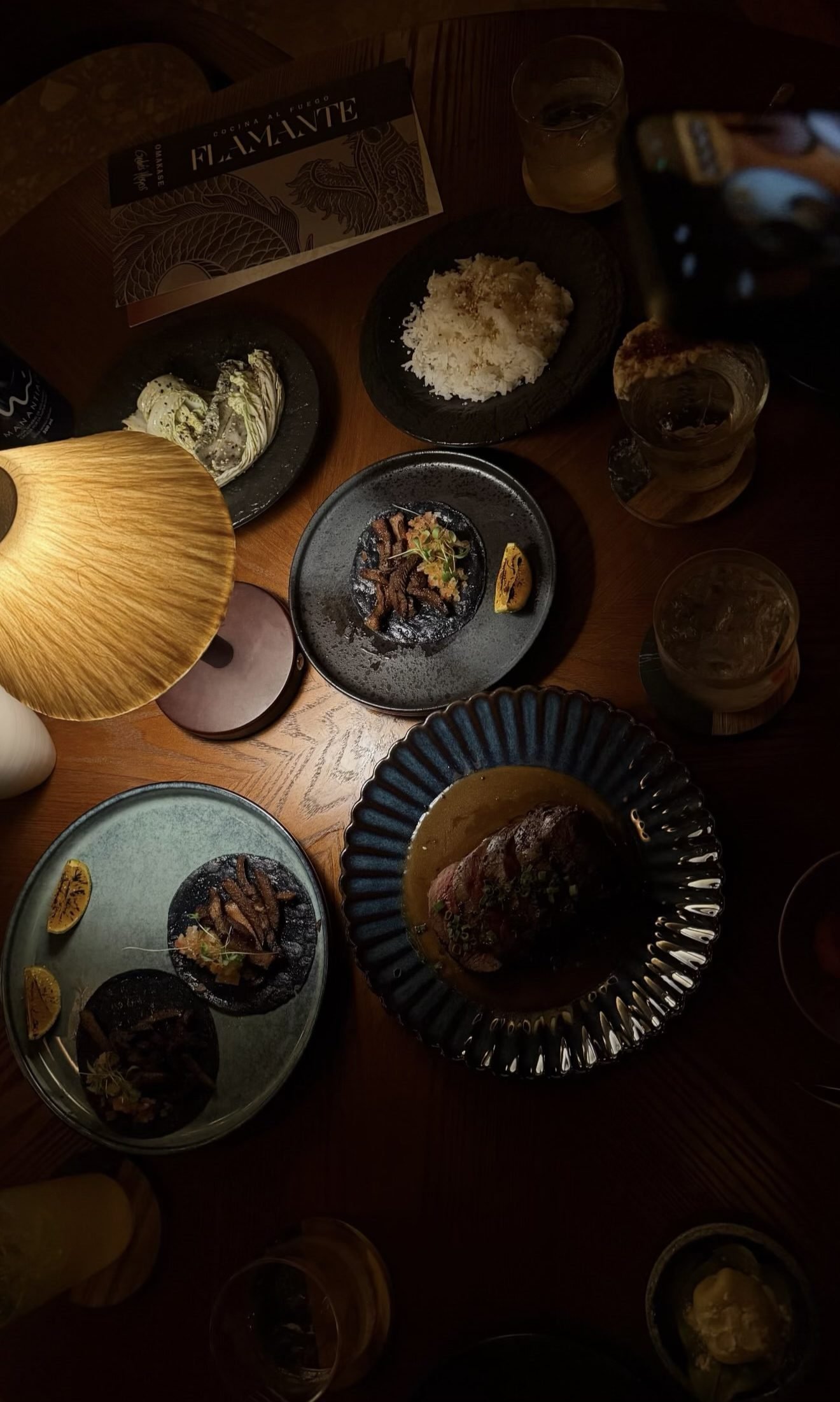 Mesa de Flamante con la carta impresa y platos para compartir